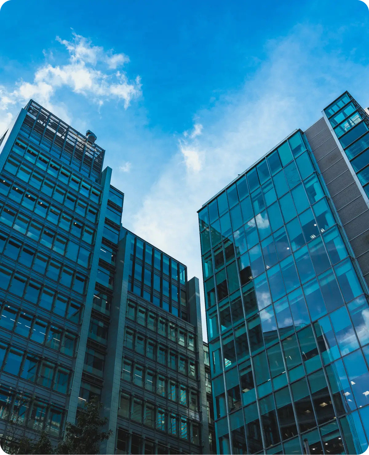 Glass skyscrapers against a bright blue sky.
