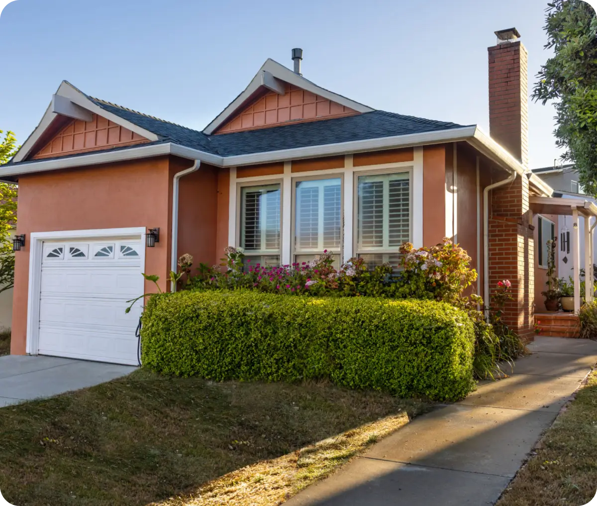 Orange house with garage and front yard.